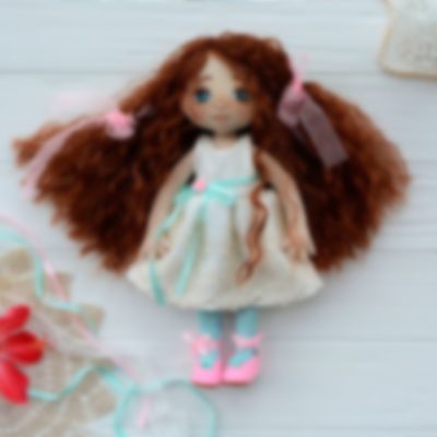 Handmade doll in bright clothes with natural hair